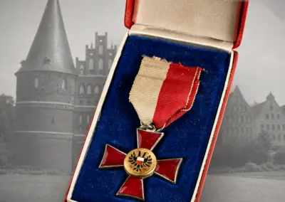 Lübeckisches Hanseatenkreuz im Originaletui, rot emailliertes Kreuz mit Stadtwappen-Medaillon, rot-weißes Band – Militaria Ankauf Lübeck